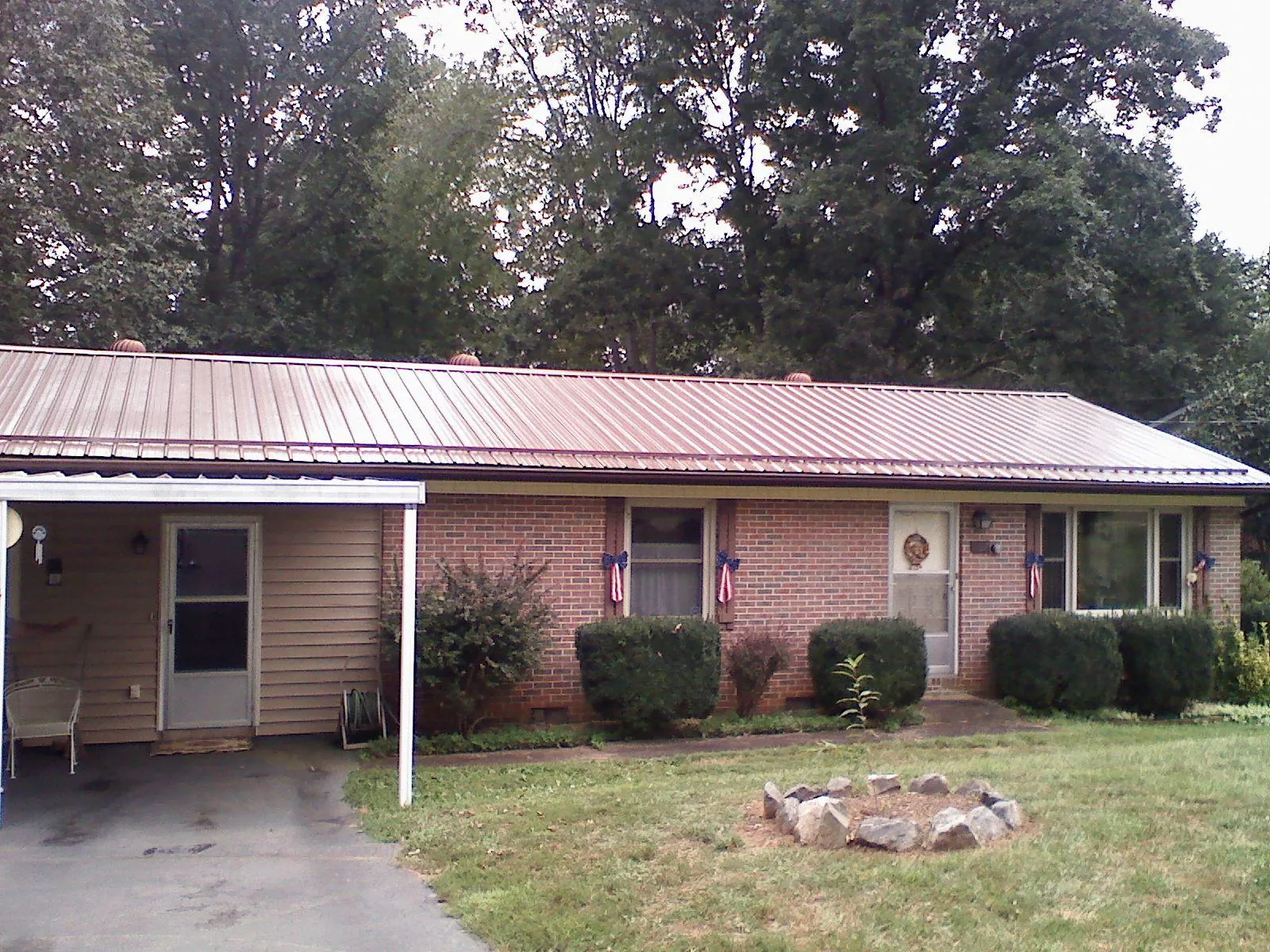 Bronze metal roof and carport on a brick ranch home — Roof Repair work by our crew in Elkton